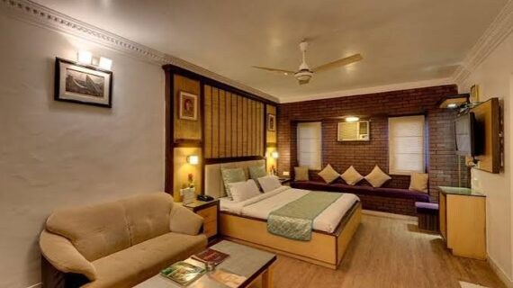 Five bed room with brick feature wall, window seating and sofa at Maharashtra Bhuvan Palitana