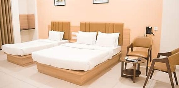 Six bed room with multiple beds and chairs at Maharashtra Bhuvan Jain Dharmshala